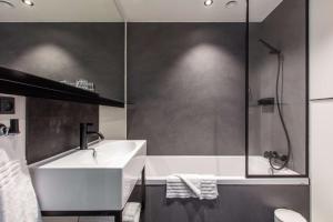 a bathroom with a sink, toilet and bathtub at The Huxley Copenhagen, BW Premier Collection in Copenhagen