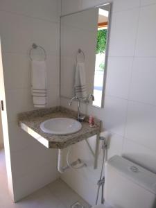a bathroom with a sink and a mirror and a toilet at Hotel Portal do Corrente in Santa Maria da Vitória