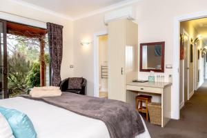 a bedroom with a bed and a desk and a mirror at The Summit Lodge in Gladstone