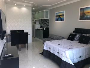 Un pequeño dormitorio con una cama y una cocina. en Flat Angra Inn, Angra dos Reis, en Angra dos Reis 34 fotos más