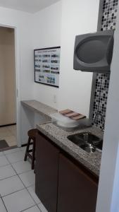 une cuisine avec un évier et un plan de travail dans l'établissement Suites Vila de Iracema, à Fortaleza