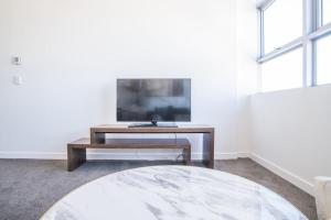 a living room with a tv and a coffee table at Train Station Access! 1Bed1Bath APT at Chatswood in Sydney