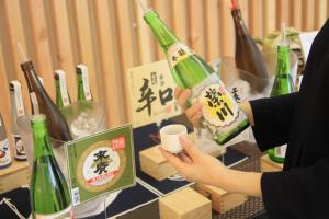 una mujer está sosteniendo una botella de vino en Yutoriro Bandai Atami en Koriyama