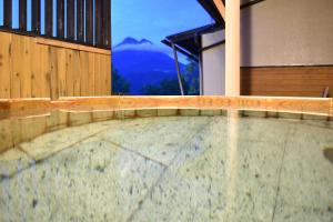a swimming pool with a view of a mountain at Yufuin Kotobuki Hananosho in Yufuin