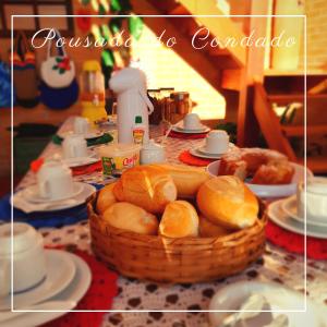 einen Tisch mit einem Korb Brot auf dem Tisch in der Unterkunft Pousada do Condado in Paraty