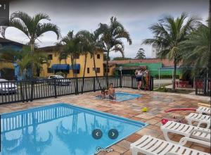 a group of people standing around a swimming pool at Associação Sabesp Bertioga - SP in Bertioga