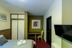 a hotel room with a bed and a desk at Ilioni Boutique Hotel in Guayaquil