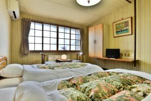 Postel nebo postele na pokoji v ubytování Takenoya Ryokan (Guest House Takenoya)