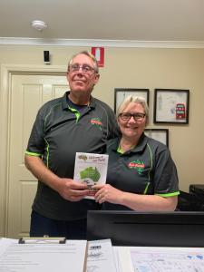 a man and a woman holding up a green plant at Holbrook Motor Village in Holbrook