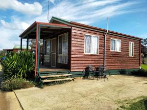 a small house with a porch and a table at Holbrook Motor Village in Holbrook