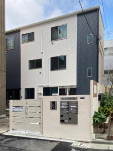 un bâtiment avec une porte devant lui dans l'établissement FL Residence Takadanobaba, à Tokyo