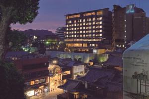 松山的住宿－Kowakuen Haruka，享有夜间城市景观和建筑