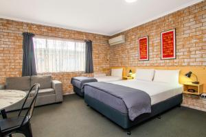 a hotel room with a bed and a couch and a table at River Street Motel in Ballina