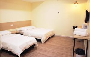 een hotelkamer met 2 bedden en een bureau bij No.31 Maple Inn in Simpang Ampat
