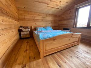 ein Schlafzimmer mit einem Bett in einer Holzhütte in der Unterkunft Берег Світязя in Switjas