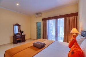 a bedroom with a large bed and a television at Nibugi Guest House in Nusa Penida