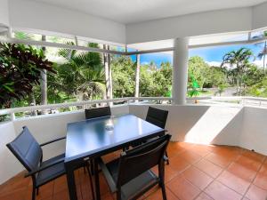 a dining room with a table and chairs on a balcony at Beach Terraces in Port Douglas
