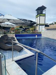 a pool with two lounge chairs and an umbrella at HV Sueño Real Tatacoa in Villavieja