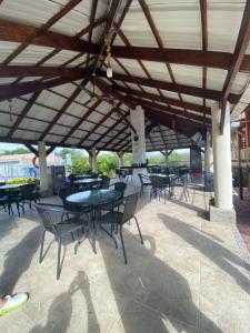 a patio with tables and chairs under a wooden roof at HV Sueño Real Tatacoa in Villavieja