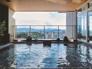 松山市にあるホテル古湧園 遥の市街の景色を望む建物内のプール