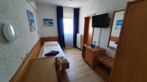 mały pokój z łóżkiem i lustrem w obiekcie Prestige Bistro & Pension w mieście Pfungstadt