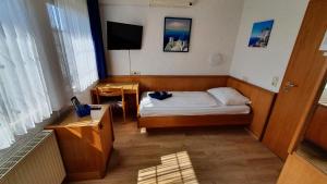 mały pokój z łóżkiem i telewizorem w obiekcie Prestige Bistro & Pension w mieście Pfungstadt