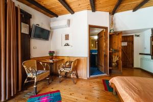 a room with a table and chairs and a television at Hotel Avion - Self check in in Plovdiv