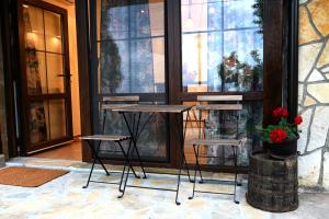 a table and two stools in front of a window at Apartman Andric 2 in Valjevo