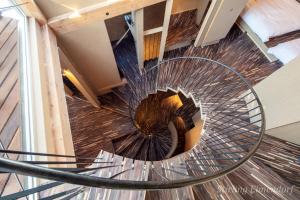 a spiral staircase with a metal railing in a building at ARCHITEKTON -the villa Tennoji- in Osaka