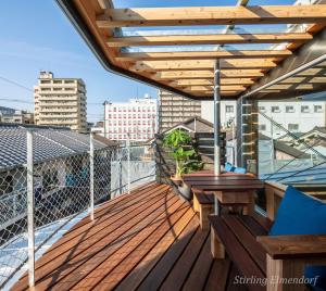 une terrasse en bois avec une table sur un balcon dans l'établissement ARCHITEKTON -the villa Tennoji-, à Osaka