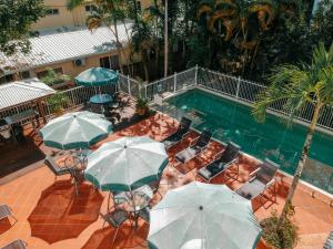 een uitzicht over een zwembad met stoelen en parasols bij Beach Terraces in Port Douglas