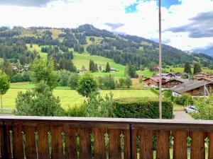 a view of a valley from a wooden balcony at Chalet Mutzli in Gstaad
