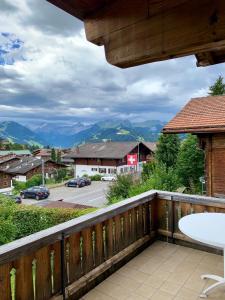 a balcony with a view of a street and mountains at Chalet Mutzli in Gstaad