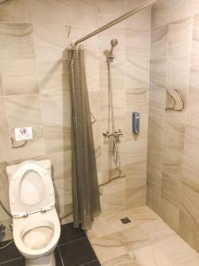 a bathroom with a toilet and a shower at The Sixteenth Naiyang Beach Hotel SHA Plus in Nai Yang Beach