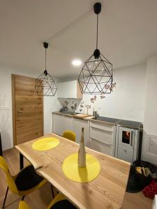 een keuken met een houten tafel met een gele hoed erop bij Apartma LUPIS in Podvolovljek
