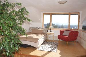 sala de estar con sofá, silla y ventana en Haus Bregenz Apartment Festspiele, en Lochau
