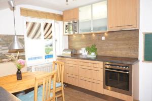 a kitchen with a wooden table and a dining room at Haus Bregenz Apartment Festspiele in Lochau