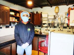 a person wearing a face mask in a kitchen at Cloud 7 in Nainital