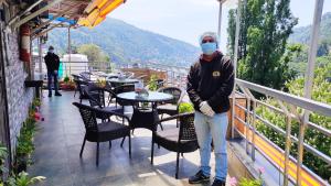 a man wearing a face mask standing on a balcony at Cloud 7 in Nainital