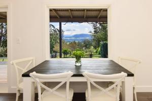 een eetkamer met een houten tafel en stoelen bij Maple Cottage in Kangaroo Valley