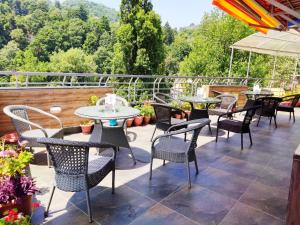 a patio with tables and chairs on a balcony at Cloud 7 in Nainital