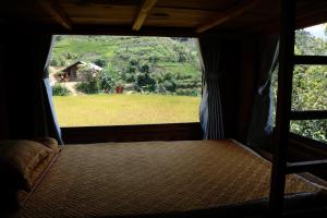 a bedroom with a window with a view of a field at Lapantan Paradise in Lao San Chay
