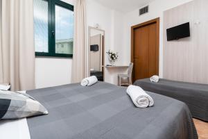 a bedroom with two beds and a desk and a television at Casa Betania in Pisa +77 photos