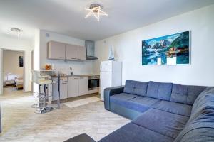 a living room with a blue couch and a kitchen at Nehaj in Senj