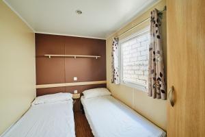 two beds in a small room with a window at Alannia Costa Dorada in Platja de l’Almadrava