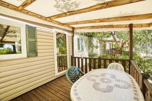 a patio with a table and chairs on a deck at Alannia Costa Dorada in Platja de l’Almadrava