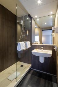 a bathroom with a sink and a shower at Mercure Versailles Chateau in Versailles