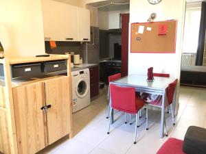 - une cuisine avec une table et des chaises rouges dans l'établissement Pigafetta n 52, à Turin