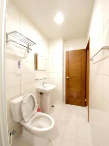 a white bathroom with a toilet and a sink at 108 House Inn in Tainan