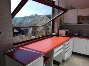 a kitchen with a red counter and a large window at Maison au soleil in Egloffstein +34 photos